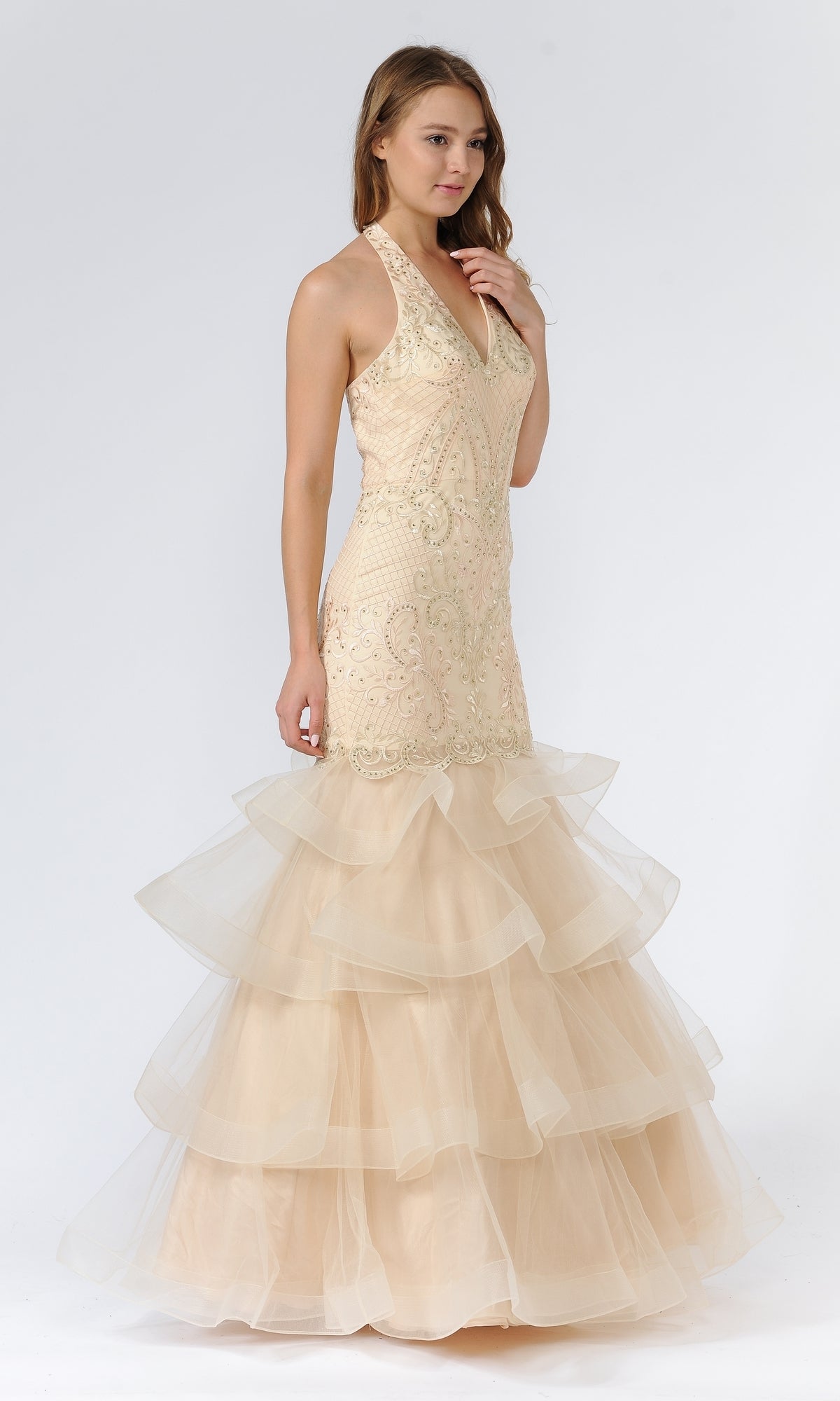 A woman in the Beaded Long Halter Mermaid Tiered Prom Dress 8466, featuring a sleeveless beaded bodice and tiered tulle skirt, stands against a plain white background.